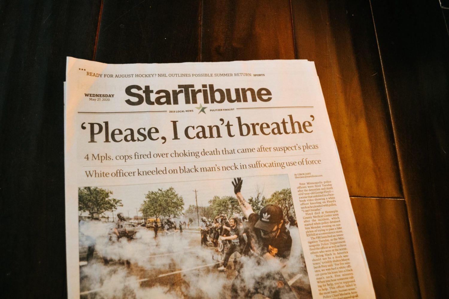 The StarTribune newspaper lays on a table with the headline, "Please, I can't breathe," referencing the 2020 police killing of George Floyd.