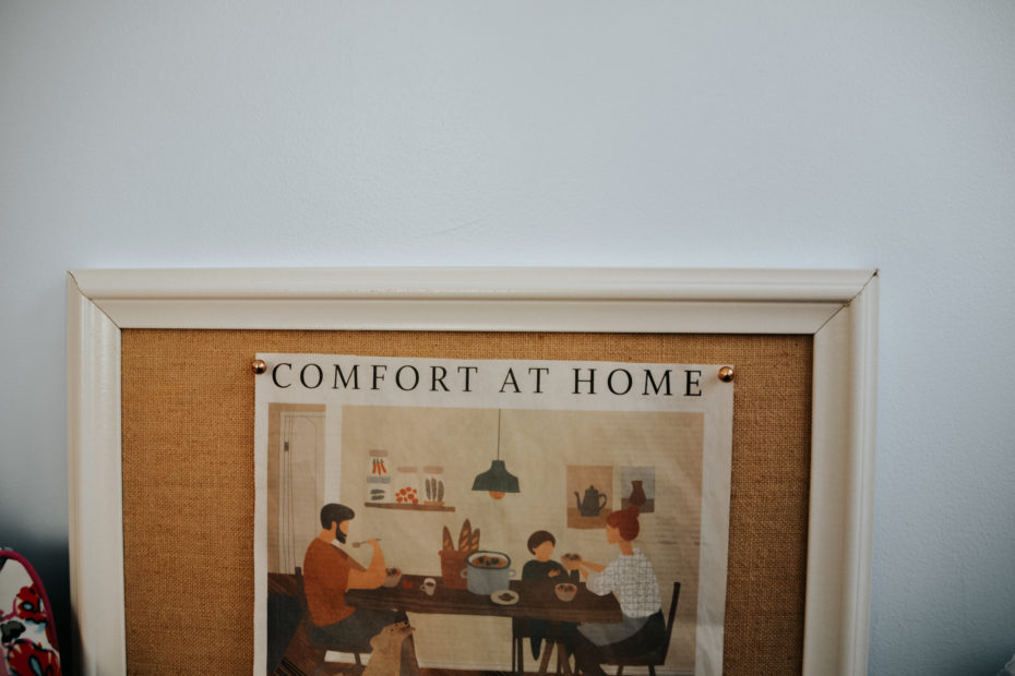 A newspaper clipping of a family seated with food around a table, labeled "Comfort at Home."